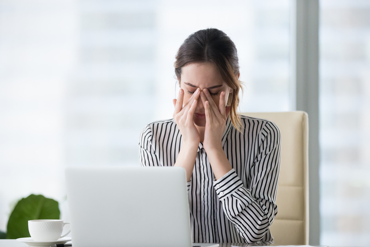 Woman straining her eyes by her computer