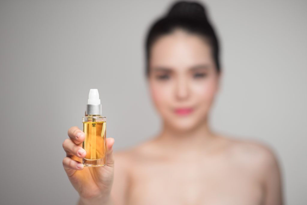 asian woman holding face oil