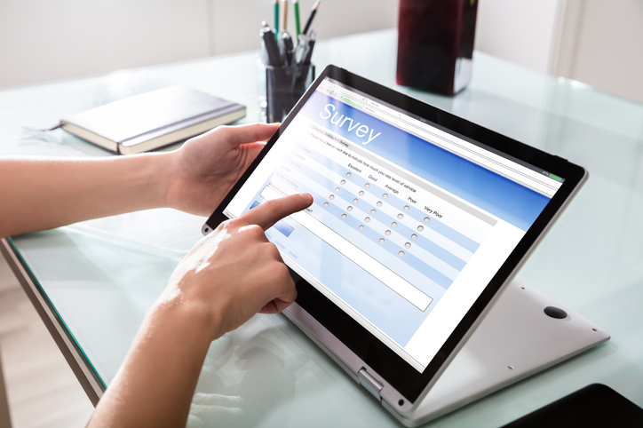 Close-up Of A Customer Hand Filling Online Survey Form On Digital Laptop In Office